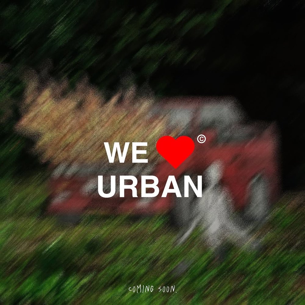Logotipo de WE ♥ URBAN sobre una fotografía desenfocada de tonos verdes y rojos, publicación de @weloveurban